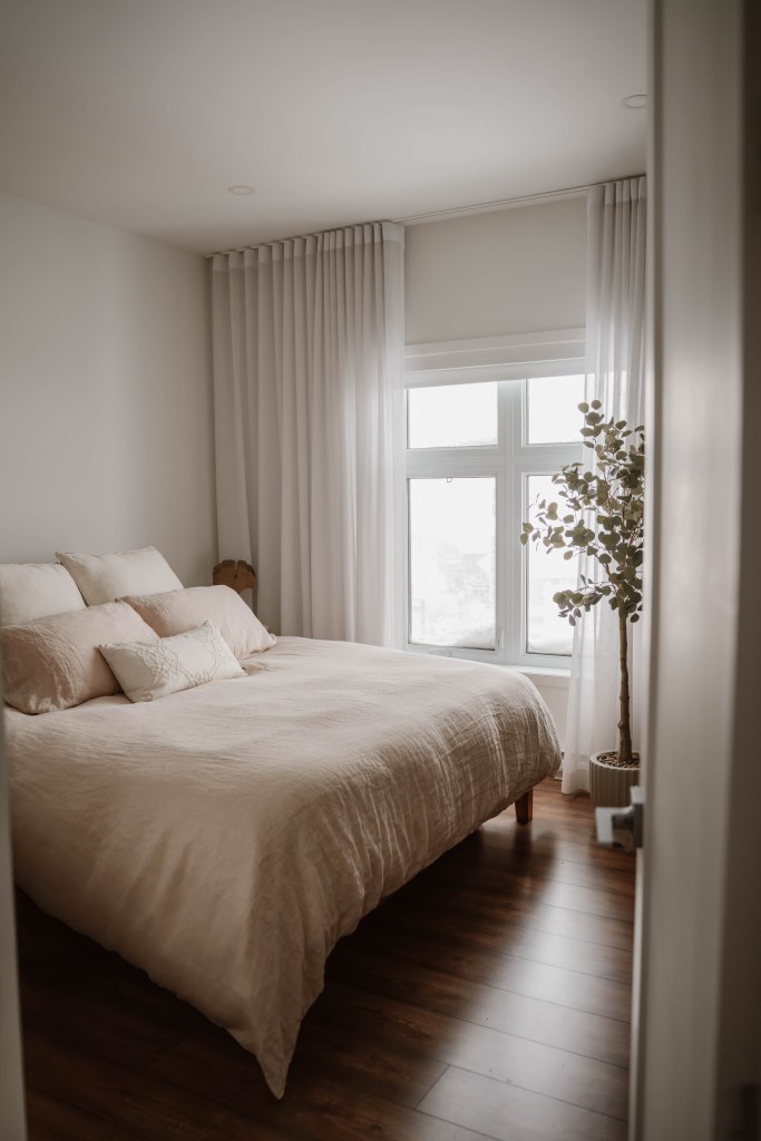 un décor de chambre des maîtres de couleur neutre avec un lit king et des draps de lin